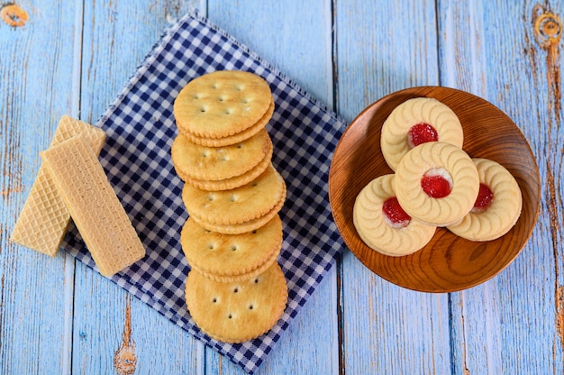 Impila molti tipi di biscotti su un piatto e metti su un tavolo di legno.