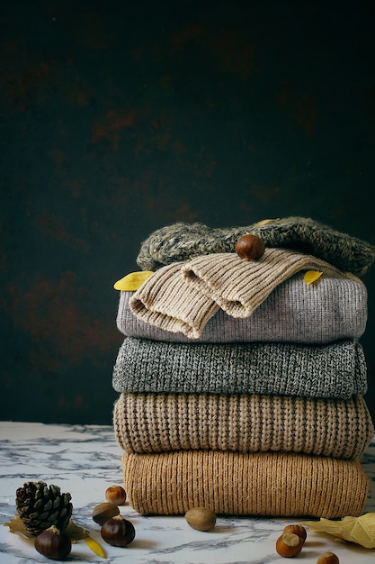 Бесплатное фото Стек из уютных вязаных свитеров. осень-зимняя концепция, вязаные шерстяные свитера. куча трикотажной зимней одежды, свитеров, трикотажа