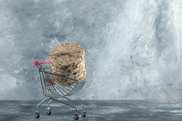 Бесплатное фото Стек вкусных хлебцев в маленькой корзине для покупок