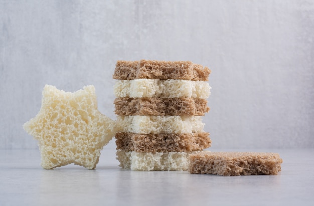 Бесплатное фото Стек ломтиков хлеба в форме звезды на каменной поверхности