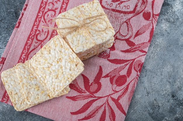 Бесплатное фото Стек вкусных хлебцев на красной ткани.