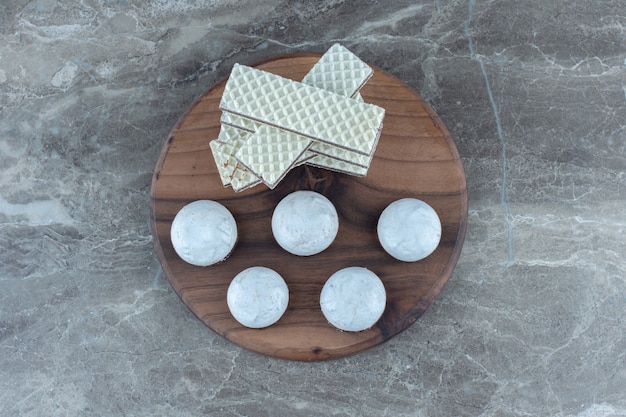 Бесплатное фото Стек вафель и печенья с белым шоколадом на деревянной доске.