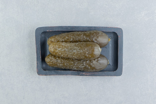 A stack of pickles cucumber on a board   