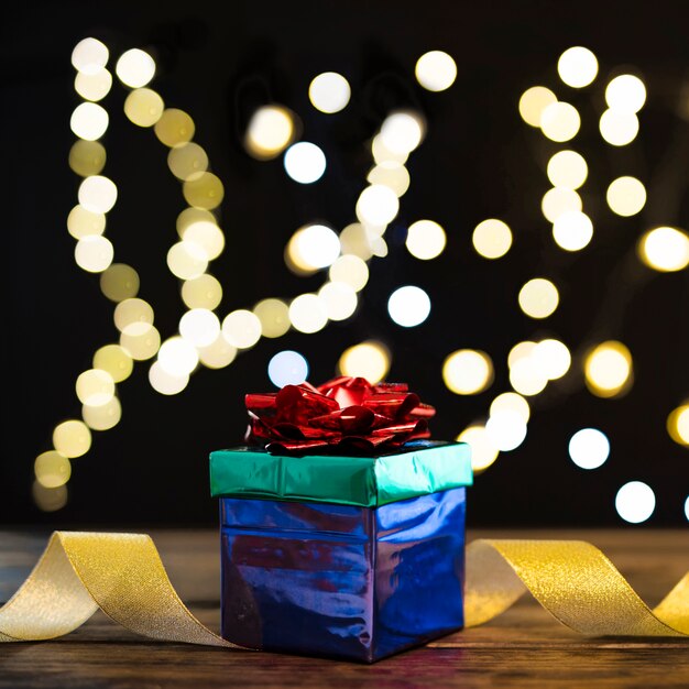 Stack of presents and ribbon near defocused lights