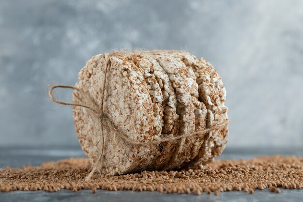 Стек рисового пирога, перевязанный веревкой на мраморной поверхности