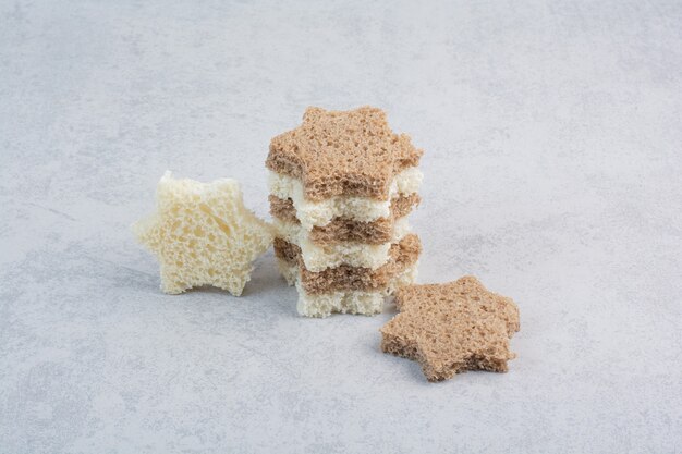 Stack of star shaped bread slices on stone surface