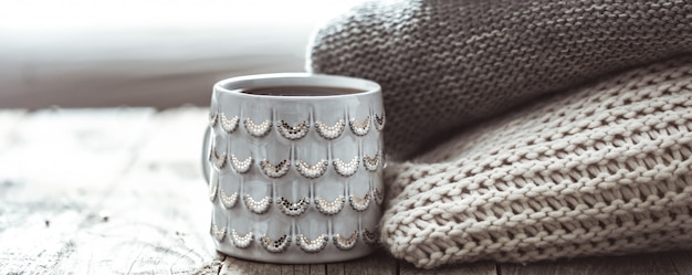 a stack of sweaters and a Cup of tea