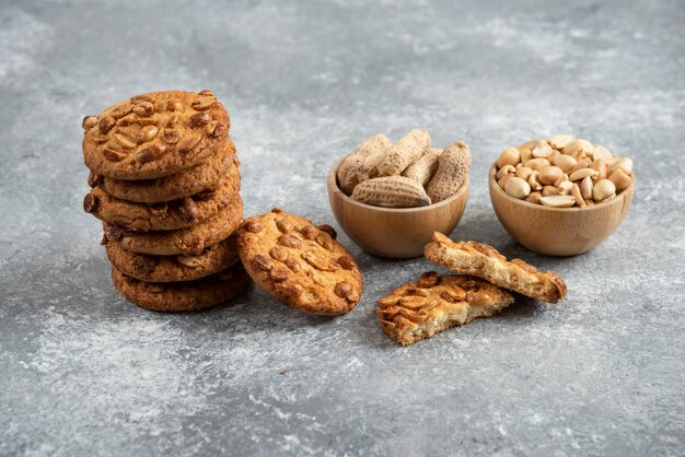 Stack of tasty biscuits and organic peanuts on marble table. 