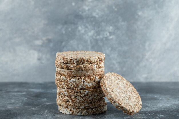 Stack of tasty crispbread on marble surface