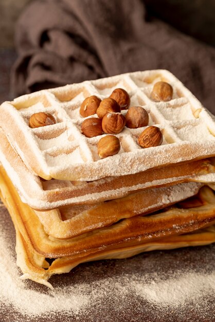 Stack of waffles with powdered sugar and hazelnuts
