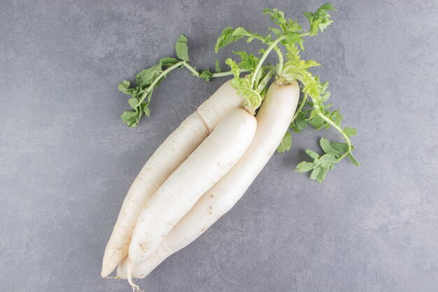 A stack of white radishes on the marble surface