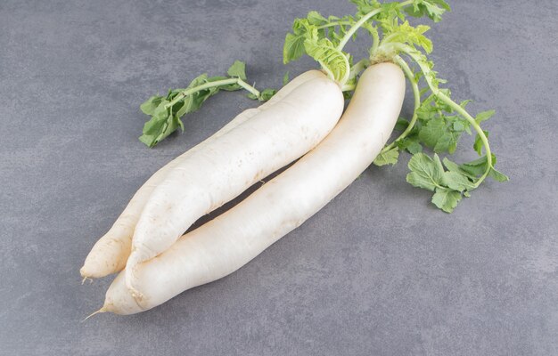 Free photo a stack of white radishes on the marble surface