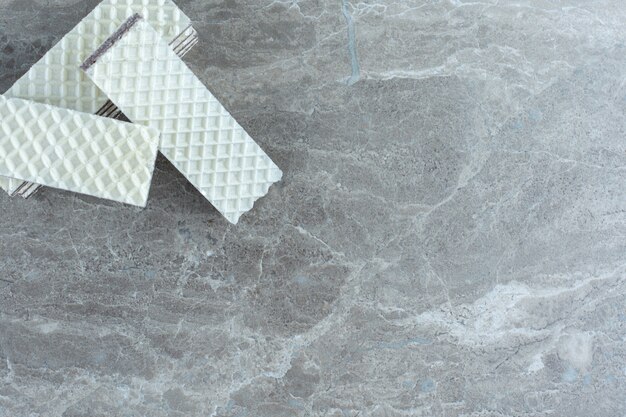 Stack of white wafers on grey background.