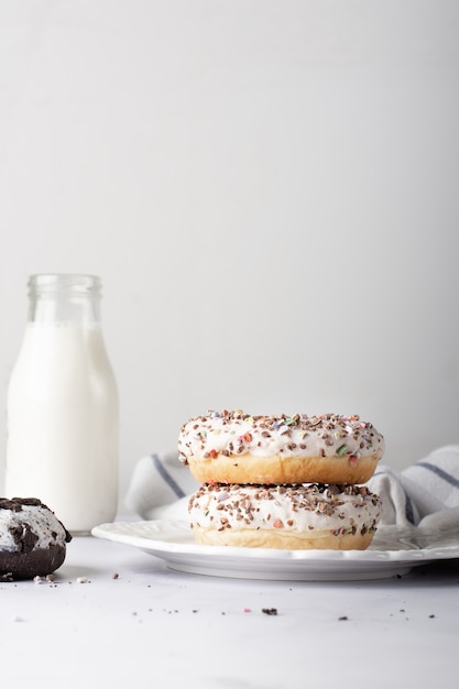 Stacked glazed doughnuts with milk bottle and copy space