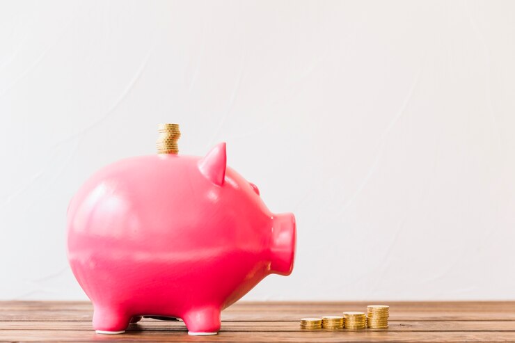 Free Photo stacked golden coins over piggybank slot on wooden surface