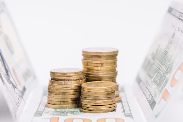 Stacked golden coins with banknotes