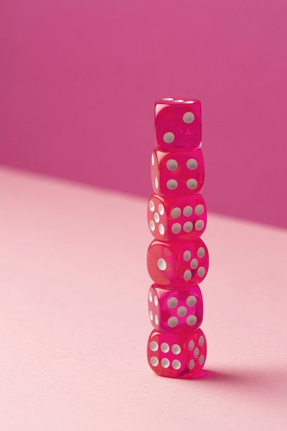 Free photo stacked pink dices on pink background