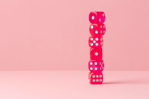 Stacked pink dices on pink background