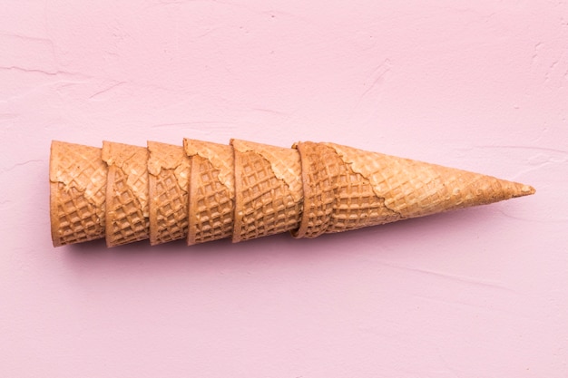 Stacked waffle cones on pink background