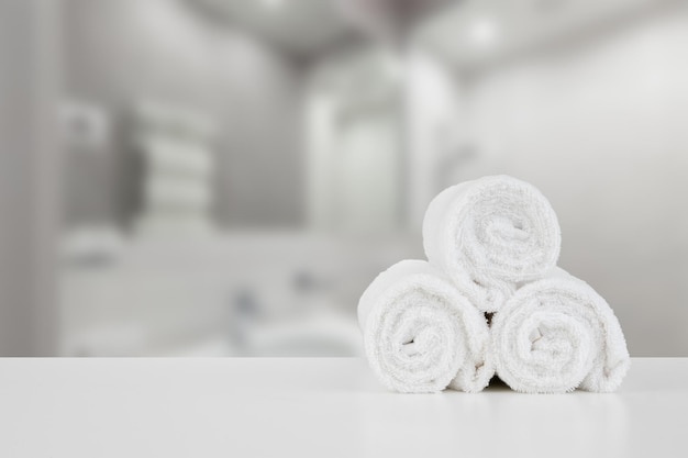 Stacked white spa towels on table against blurred background