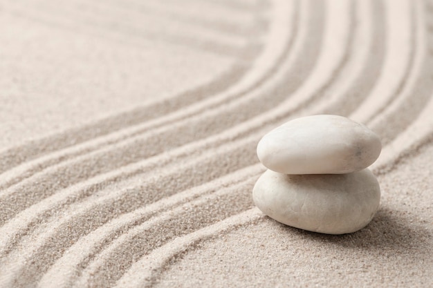 Сложенные дзен мраморные камни песчаный фон в концепции осознанности