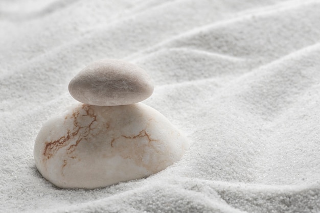 Free photo stacked zen stones sand background in art of balance concept