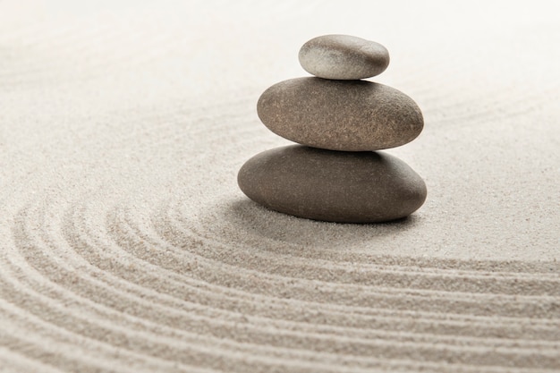 Бесплатное фото Сложенные дзен камни песок фон искусство баланса концепции