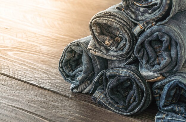 stacks of jeans clothing on wood