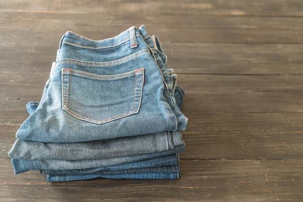 stacks of jeans clothing on wood