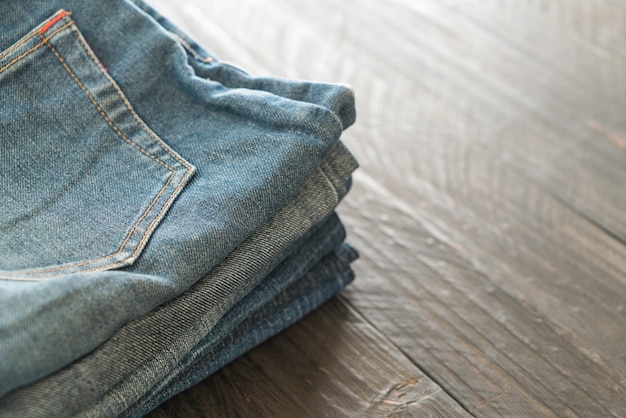 stacks of jeans clothing on wood