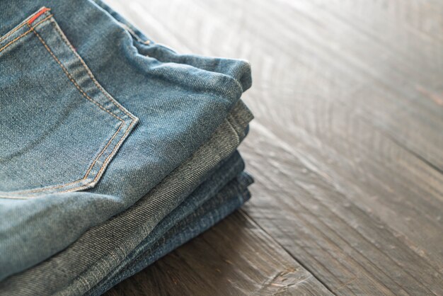 stacks of jeans clothing on wood