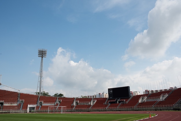 Stadium background with a green grass pitch in the daytime