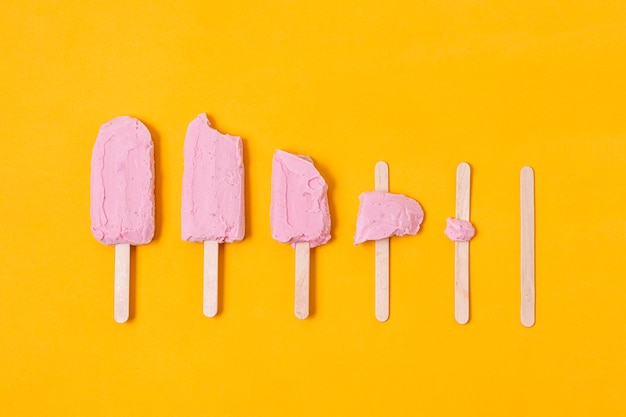 Free photo stages of eaten ice cream of stick top view