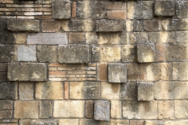 Stained brick wall with uneven blocks