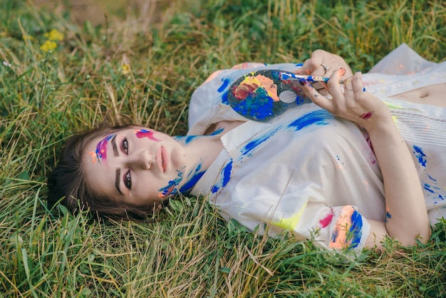 Stained paint woman lying on the ground viewed from above