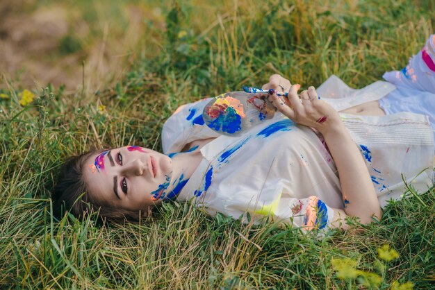 Stained paint woman lying on the ground viewed from above