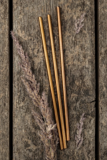 Stainless metallic golden straws on wooden background