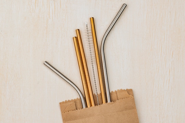 Stainless metallic straws in a paper bag