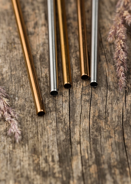 Stainless metallic straws on wooden background