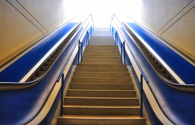 Staircase and two escalators under the lights in a building