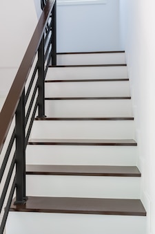 Лестница в современном стиле коричневого и белого дерева в помещении