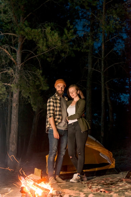 Standing couple looking at the campfire