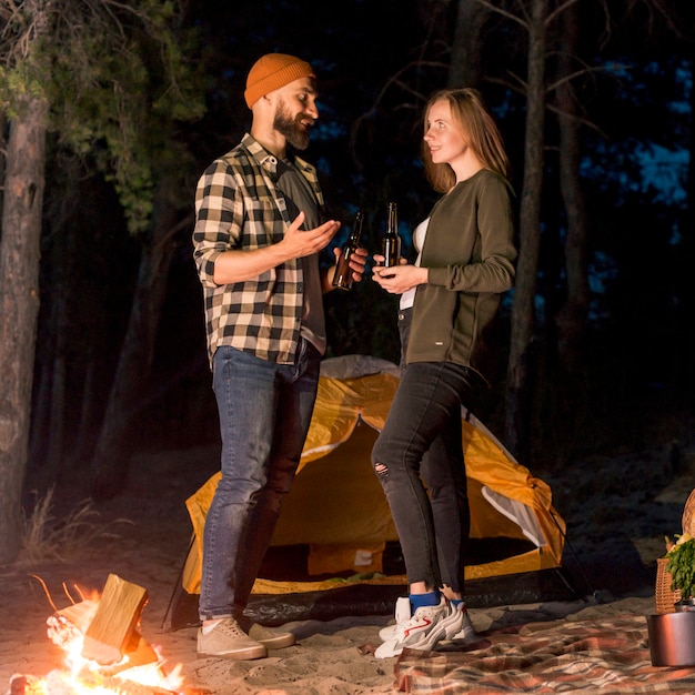 Standing couple talking by camping tent