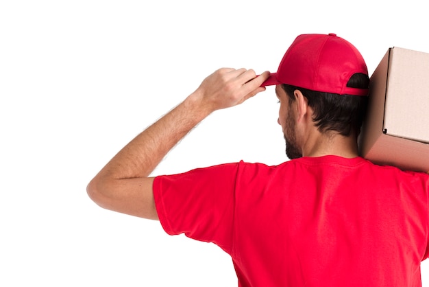 Free photo standing courier man holding box and cap from the back shot close-up