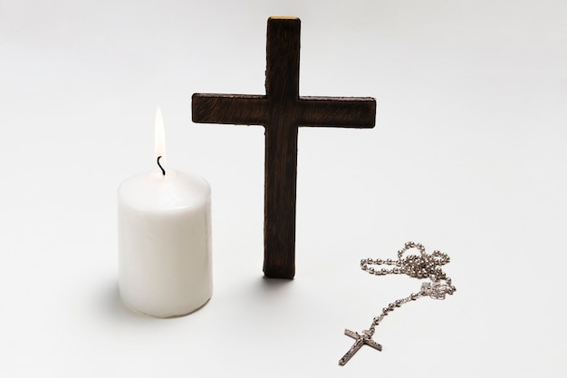 Standing cross with lit candle and necklace