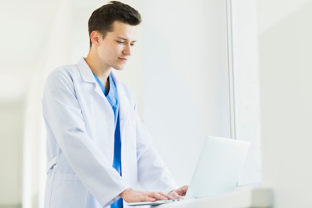 Standing doctor with laptop