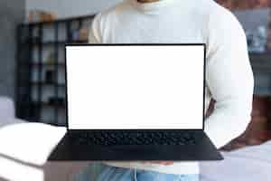 Foto gratuita mock-up del computer portatile della holding dell'uomo in piedi