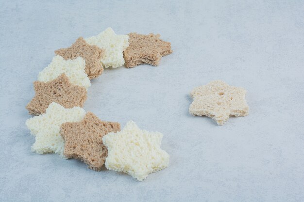 Foto gratuita fette di pane bianco e nero a forma di stella su fondo di marmo. foto di alta qualità