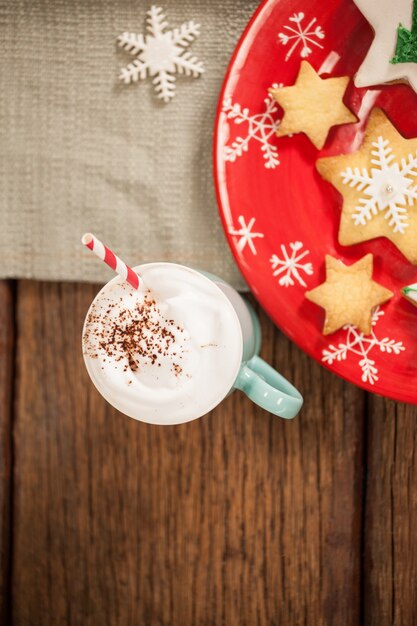 Star shaped cookies on a red plate and cup with cream