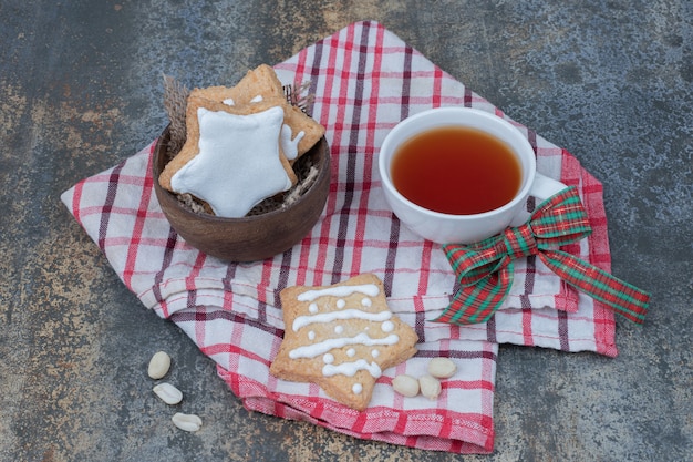 Star shaped gingerbread cookies and cup of tea on tablecloth. High quality photo